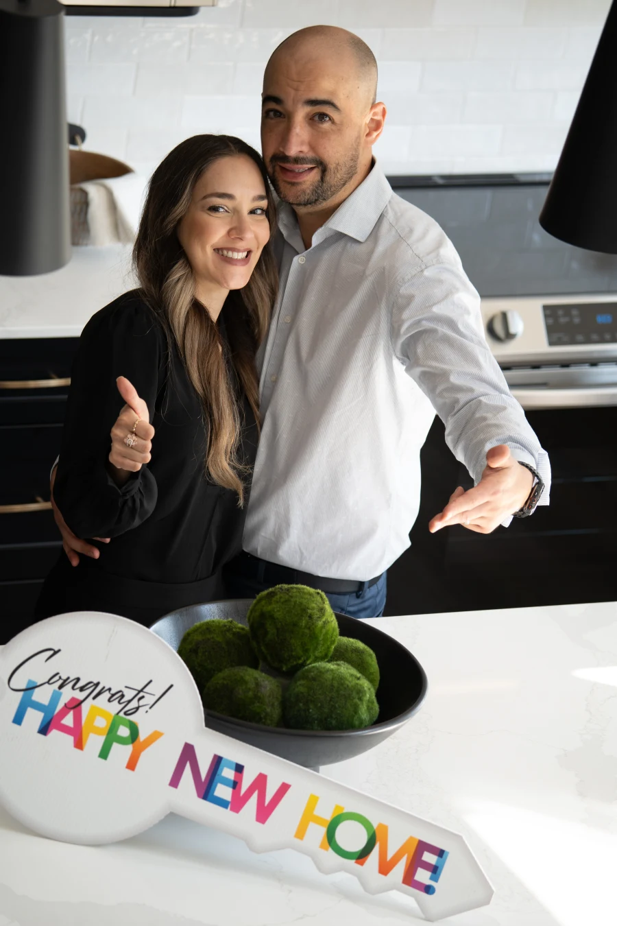 Enrique y Lore con una llave de celebración de nueva casa en una cocina
